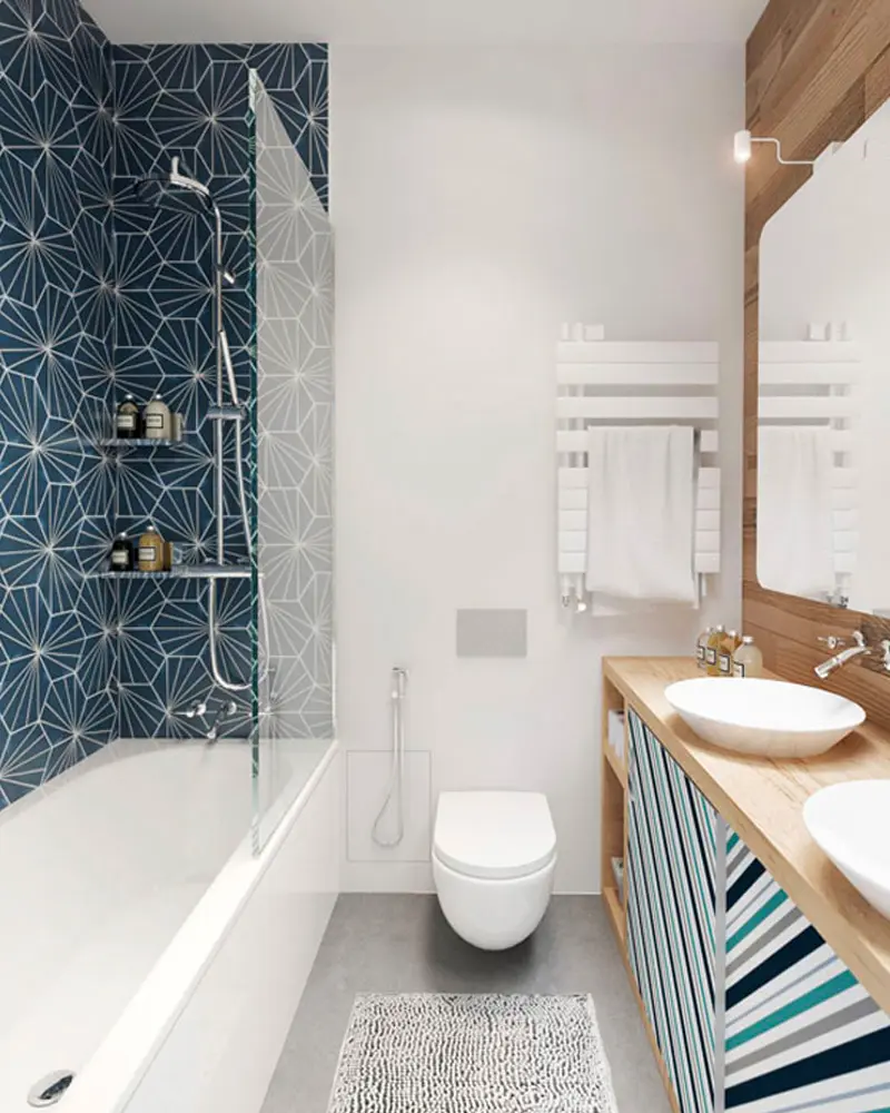 Navy star-pattern tile shower wall above a tub, white towel warmer and striped vanity