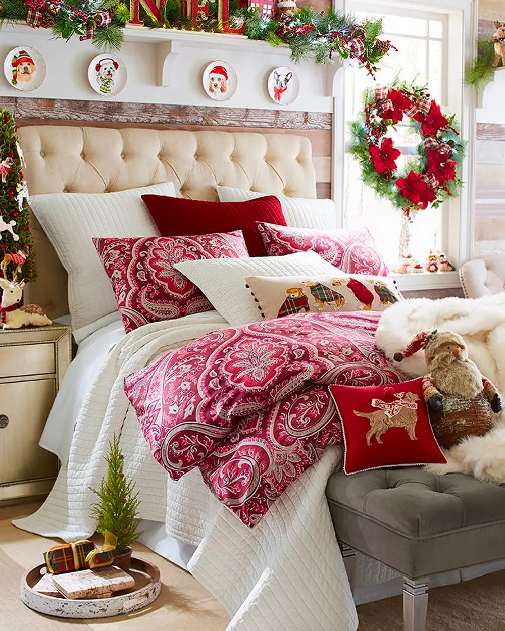 Bed with red paisley duvet, velvet red pillows, a poinsettia wreath and a tufted headboard