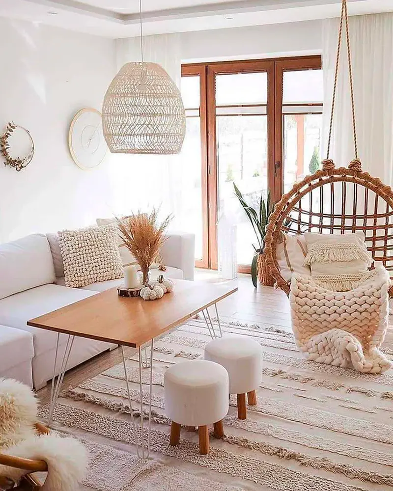 Hanging rattan egg chair, wood and hairpin coffee table, white stools and woven pendant