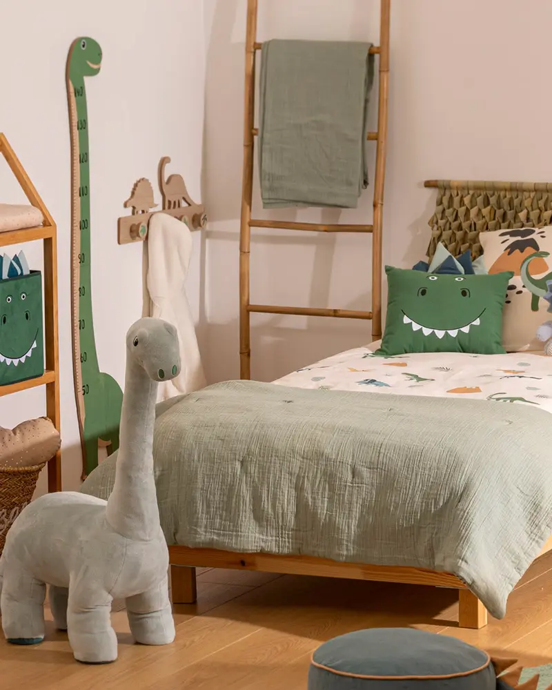 Kids room with sage bedding, plush gray dinosaur, dinosaur growth chart and bamboo ladder