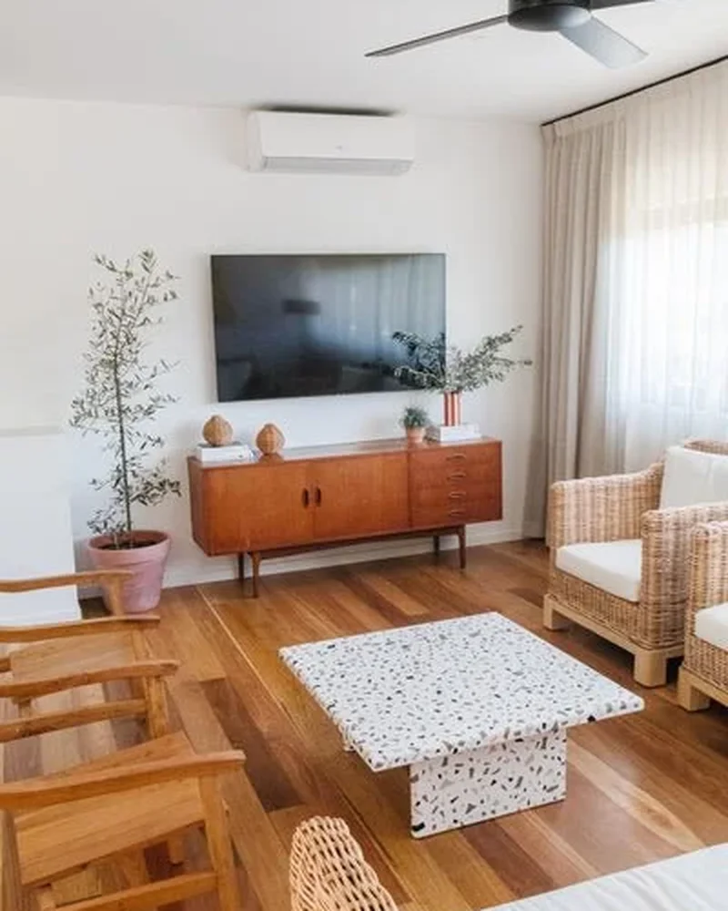 Living room with a square terrazzo-topped coffee table on a wood floor