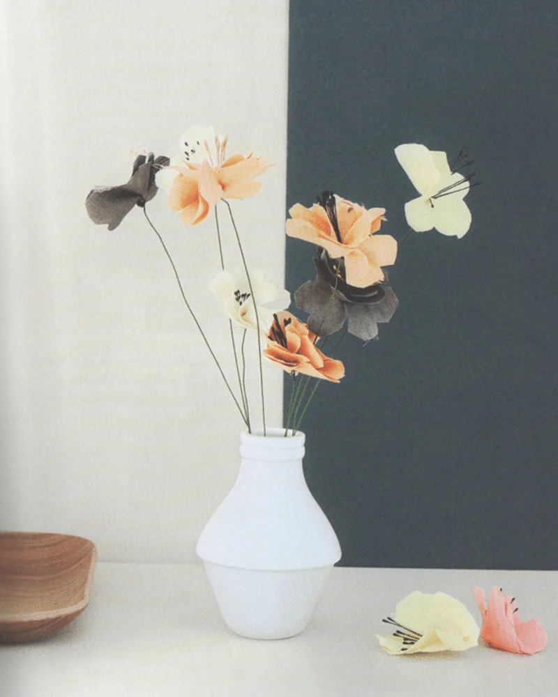 Delicate peach, gray and cream fabric flowers on wire stems in a white vase
