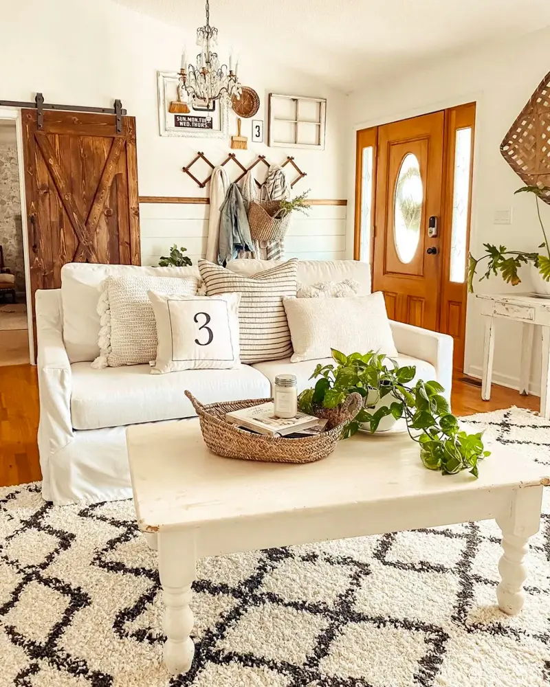 Sliding barn door, a white sofa, a crystal chandelier and a black and white diamond rug
