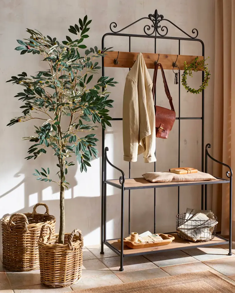 Wrought iron hall tree with coats, baskets and potted tree
