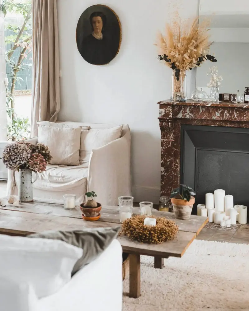 Marble fireplace with candles, dried wheat and an old portrait