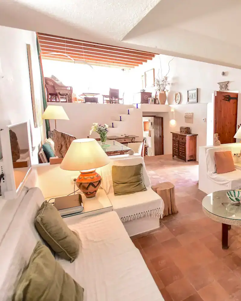 White sofas, a terracotta tile floor and a ceramic lamp in a bright Mediterranean-style living room