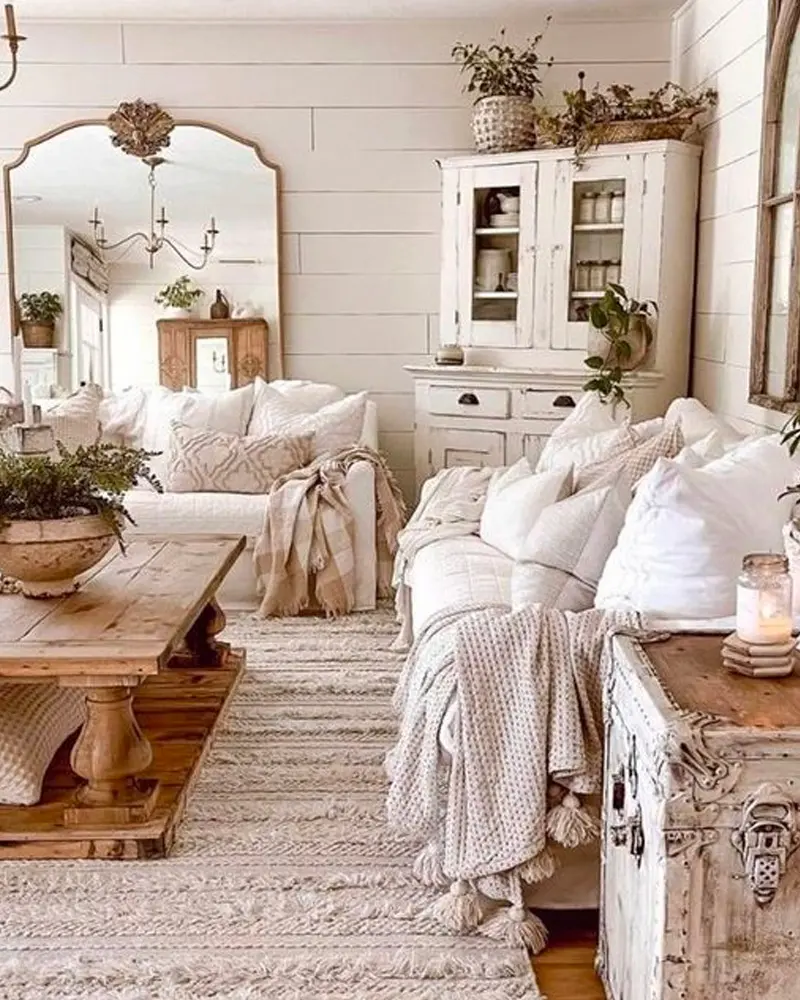 White shiplap living room with an arched mirror, a white hutch and chunky knit throws