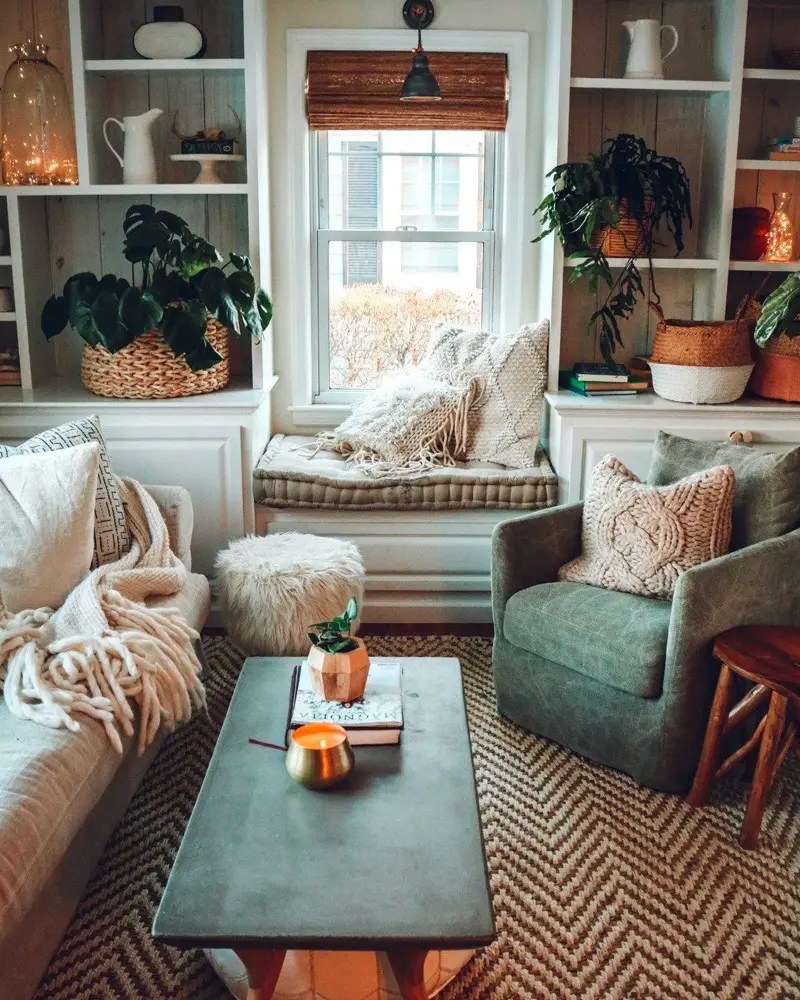 Window seat between built-in shelves, a green armchair and a herringbone rug