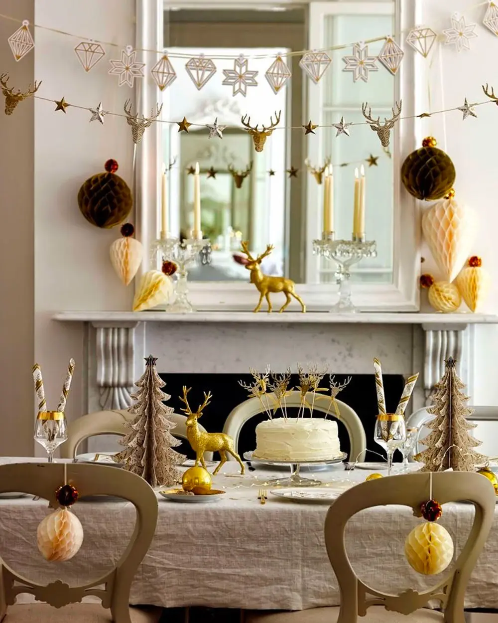 Mantel and dining table in beige and gold with honeycomb ornaments, gold reindeer and a paper garland