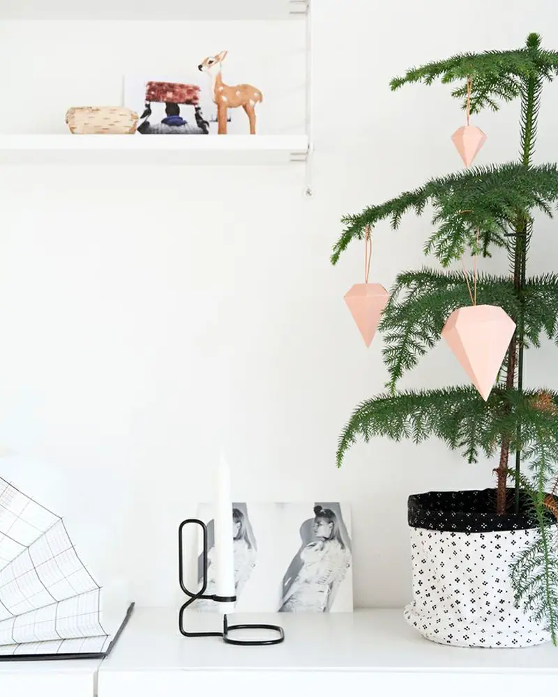 Small Norfolk pine in a printed fabric pot with pink paper diamond ornaments