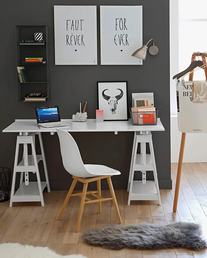 Charcoal wall with white trestle desk, molded chair, typographic posters and faux fur rug