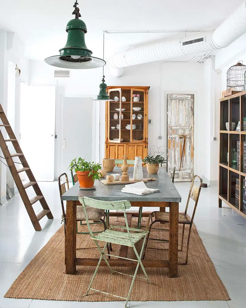 Green enamel pendant over a wood table with a mint folding chair, jute rug and wood ladder