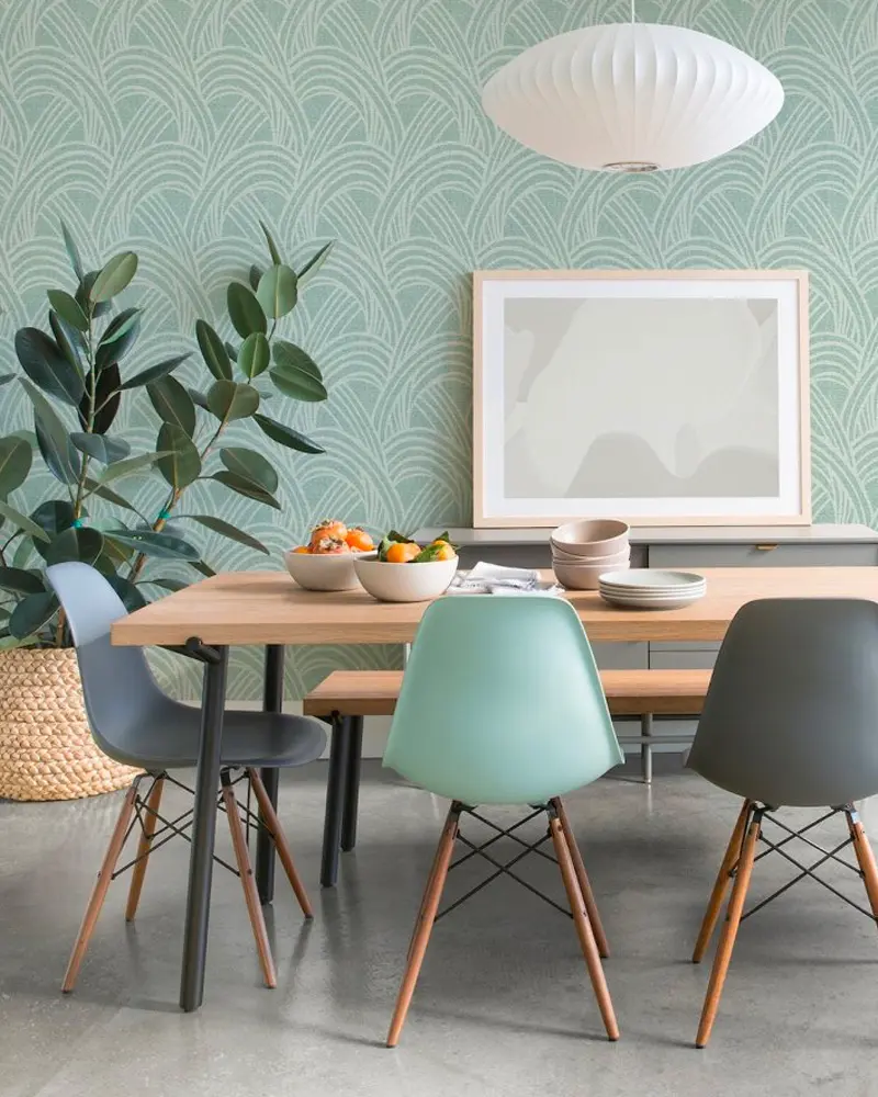 Seafoam patterned wallpaper, wood table with molded chairs in gray and mint, paper lantern pendant