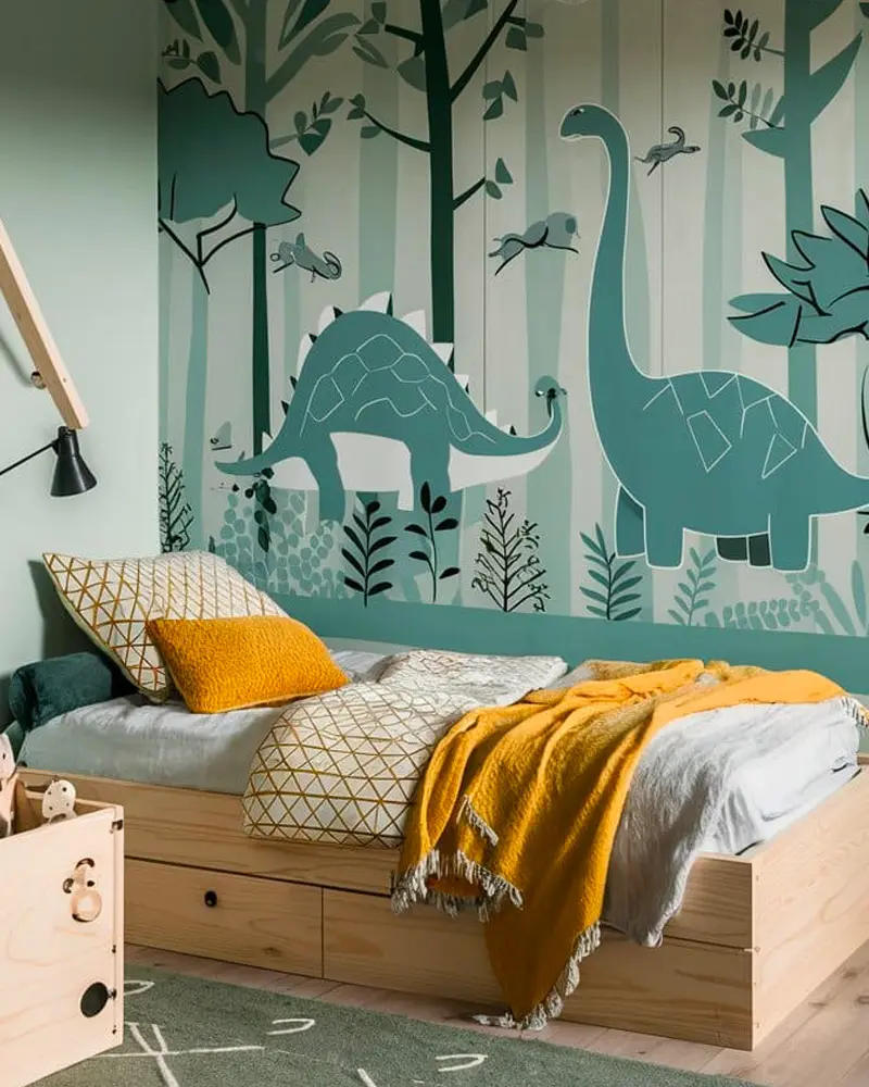 Kids room with teal dinosaur forest mural and wooden bed with mustard throw