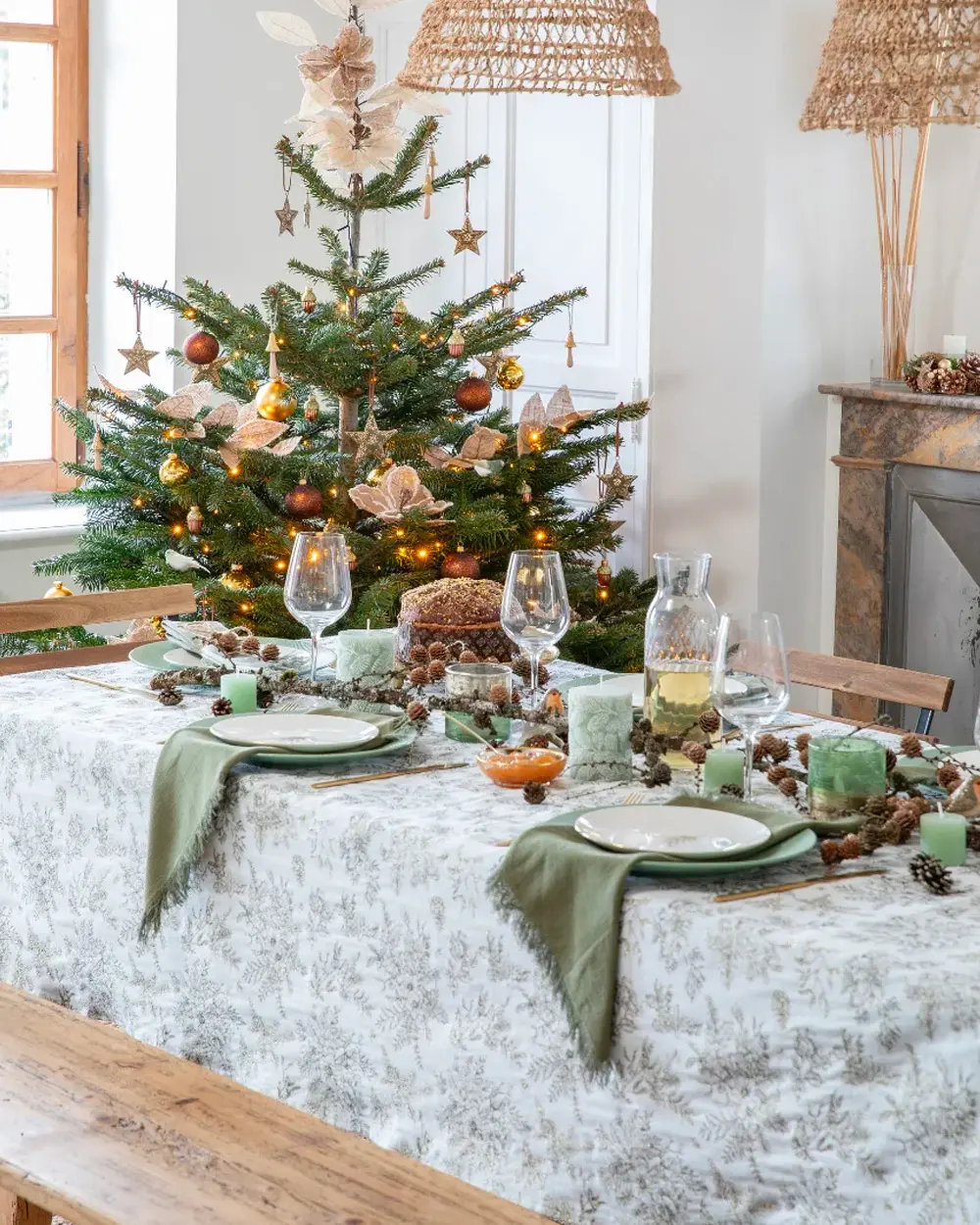 Long table with a sage botanical tablecloth, green napkins and a tree with natural ornaments