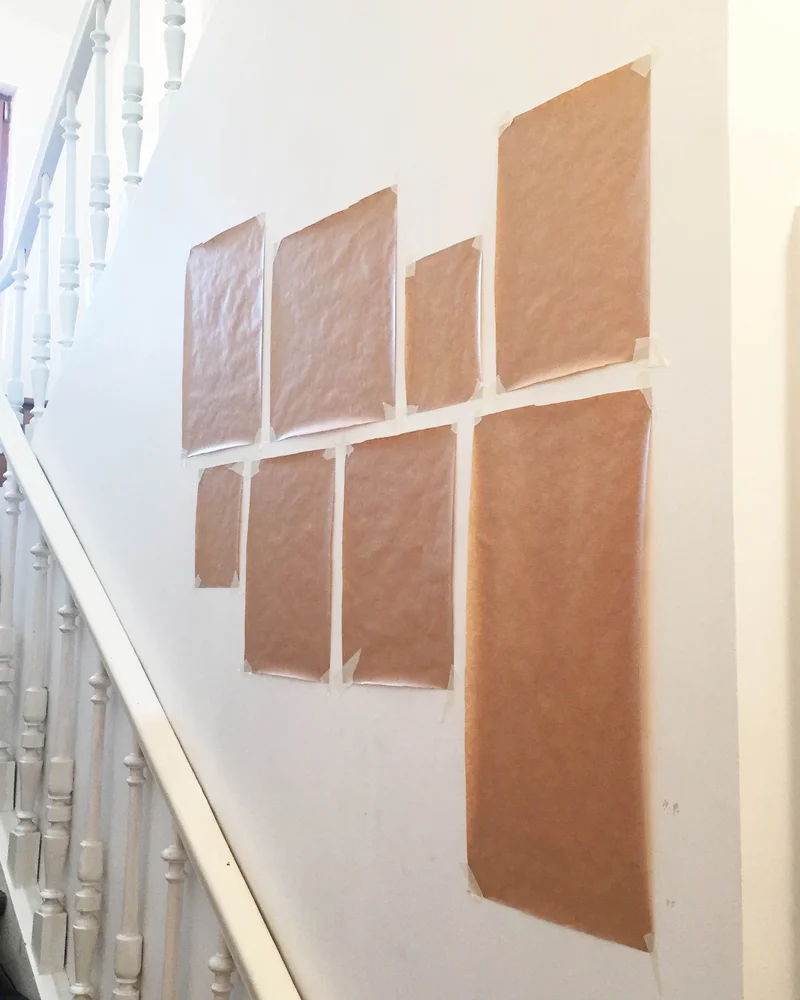 Kraft paper templates taped to a staircase wall