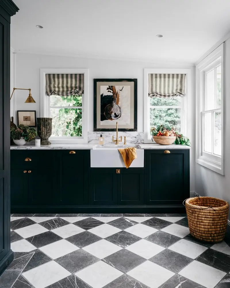 Black cabinets, striped Roman shades and a black and white checkerboard marble floor