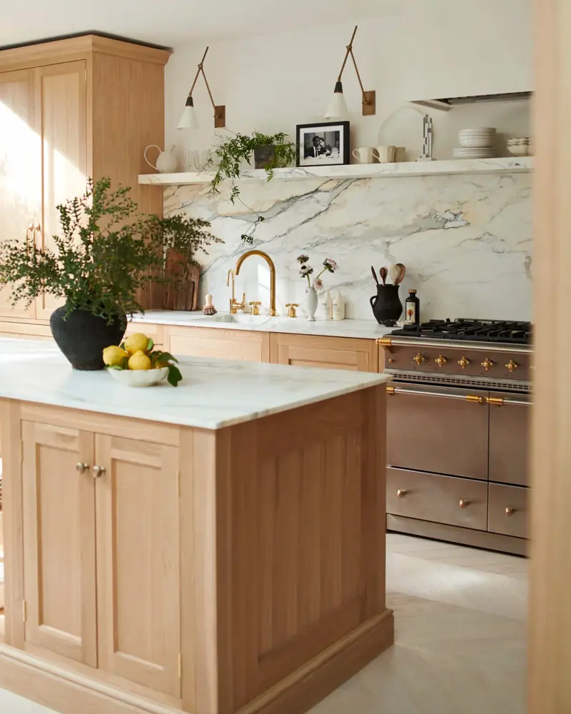 Oak island with a marble top, a marble slab backsplash and a stainless range