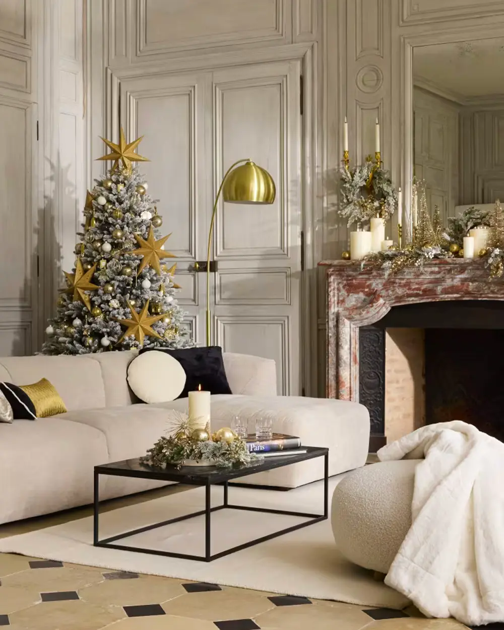 Modern living room with a white curved sofa, gold floor lamp and a flocked tree with gold stars