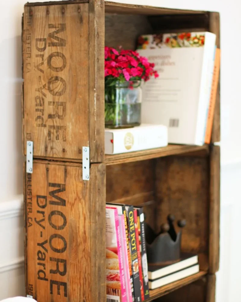 Tall bookshelf of old wooden crates stamped with vintage lettering