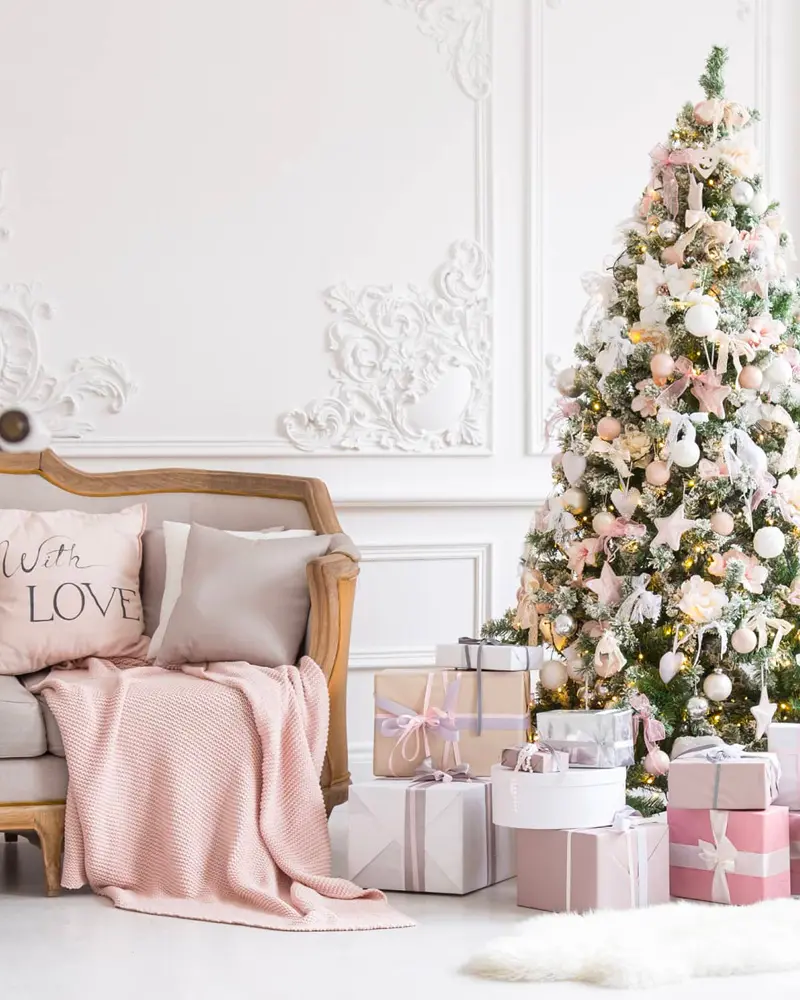 White paneled living room with a vintage settee, pink throw, LOVE pillow and a tree decorated in pink and white