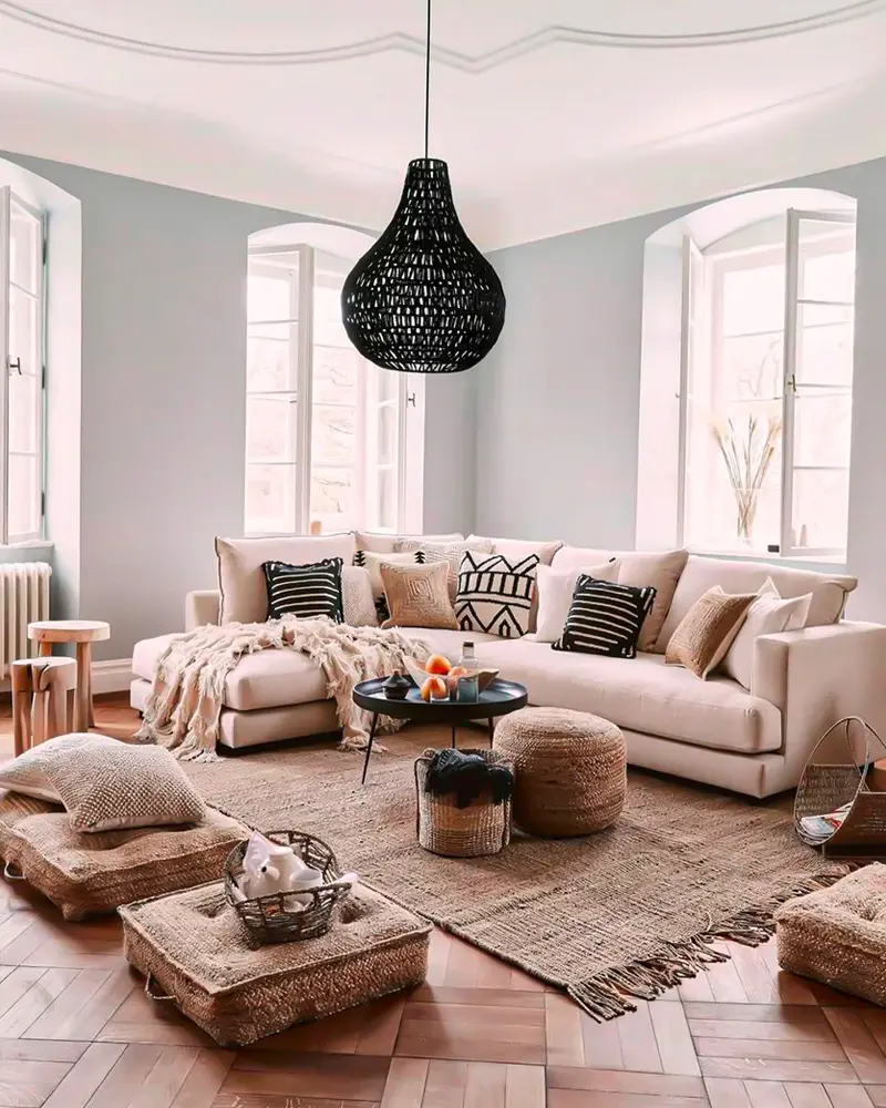 Living room with black woven pendant, floor cushions, rattan poufs and beige sofa