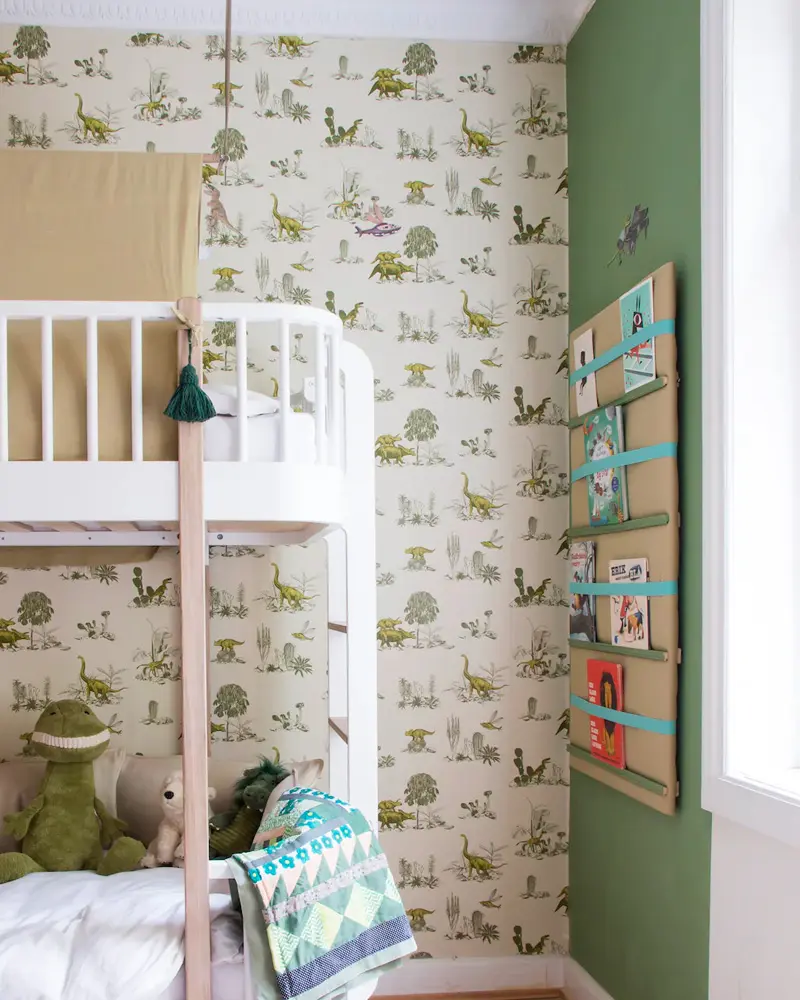 Shared kids room with white bunk bed, dinosaur and cactus wallpaper and green wall