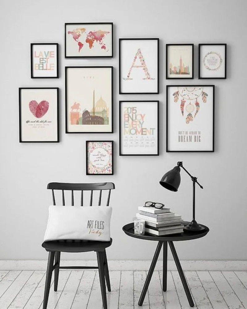 Gallery wall of travel and typography prints above a black chair and side table