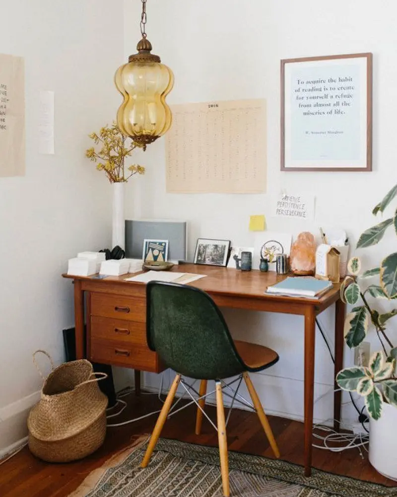 Teak desk with drawers, green molded chair, amber glass pendant and woven basket