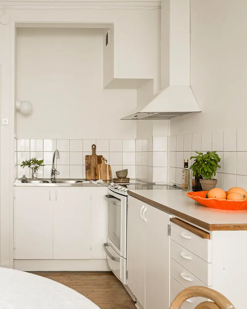 White kitchen with wood countertop, subway tile and range hood
