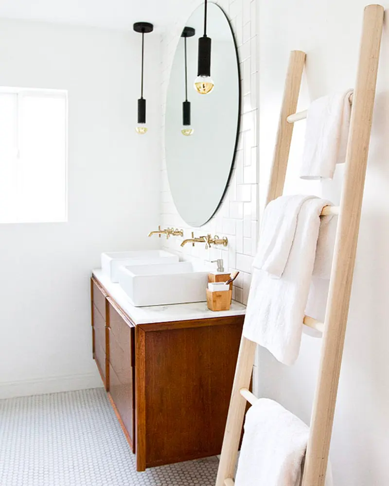 Wood vanity with double vessel sinks, pill mirror, black pendants and wood towel ladder