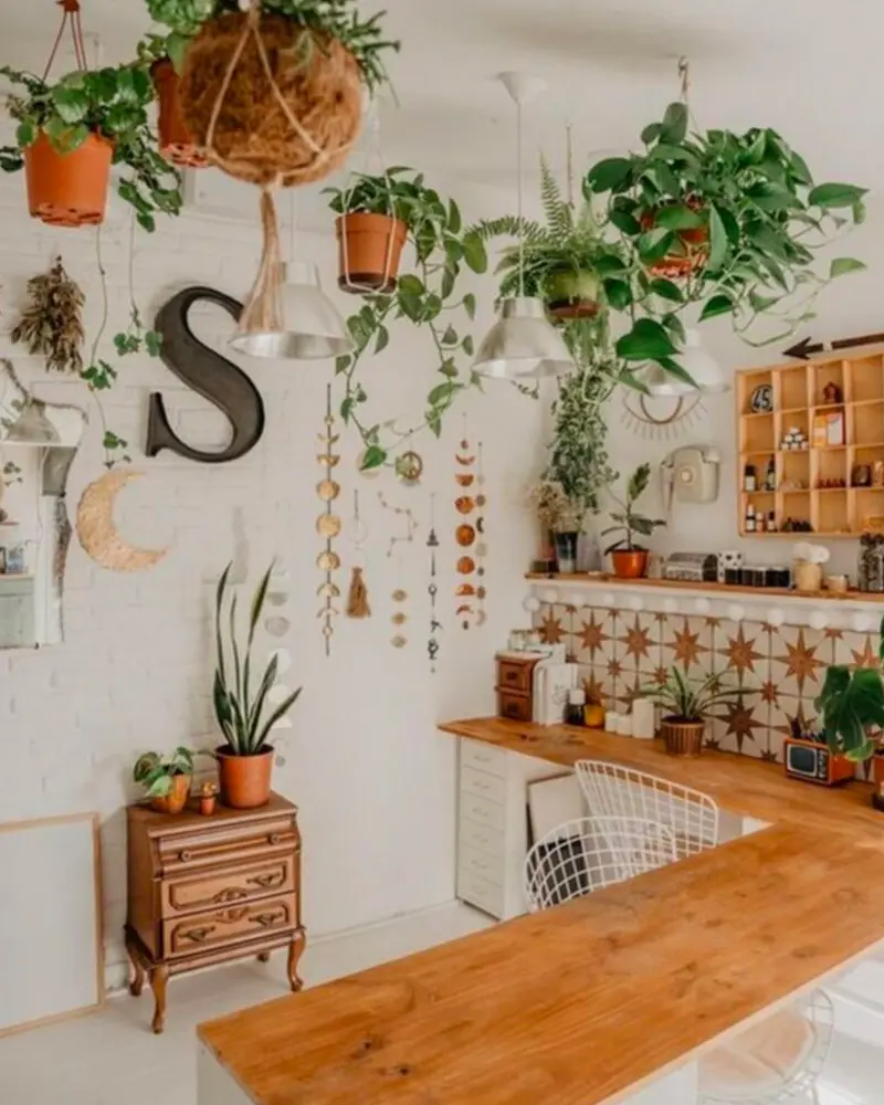 White kitchen wall with hanging plants, wood letter S, wood counter and vintage cabinet