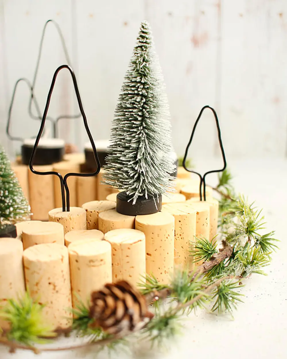 Ring of upright wine corks with bottle-brush trees, wire tree shapes and pinecones