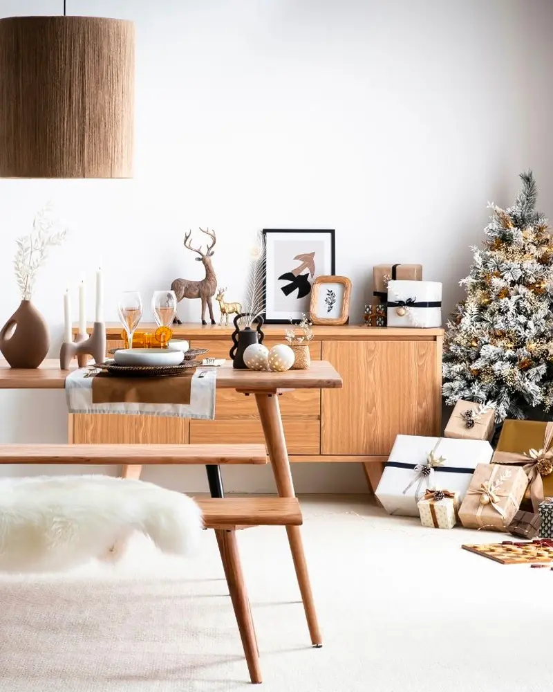 Teak sideboard with a wooden reindeer, a flocked tree, sheepskin and a wood dining table