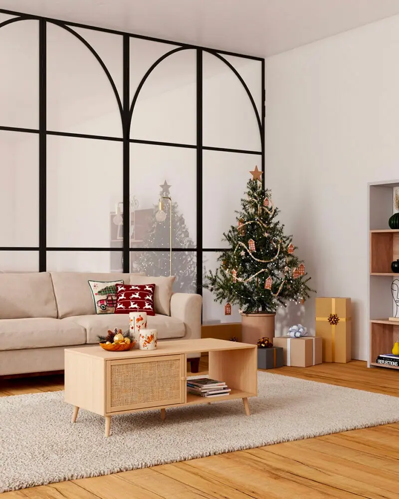 Cane-front wood coffee table, a beige sofa with red pillows and a small tree by a black-framed glass wall