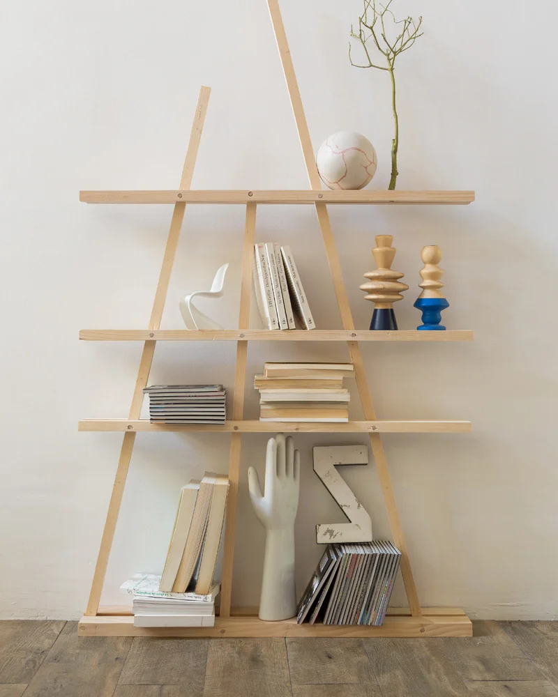 Triangular A-frame wood strip shelf with books and decorative objects